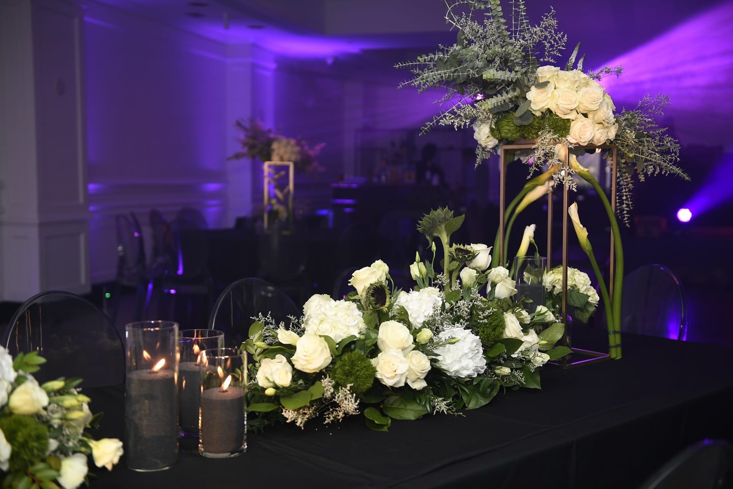 Gold geometric stand of white roses and calla lilies at a Bar Mitzvah head table